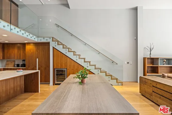a view of a kitchen with kitchen island wooden floor and stainless steel appliances