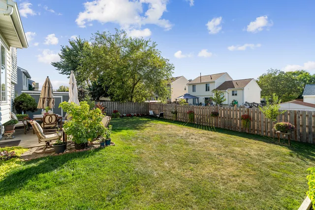 a backyard of a house with table and chairs