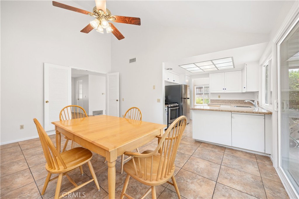 3430 Bahia Place Riverside, CA 92507 - Photo 13 of 34 a kitchen with stainless steel appliances kitchen island granite countertop a dining table chairs and white cabinets