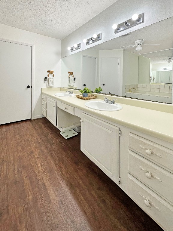 16230 Katherine Lane Channelview, TX 77530 - Photo 15 of 19 spacious bathroom with dual sinks, a large mirror, and ample cabinetry. The room features a warm wooden floor and bright lighting, creating a clean and inviting space.