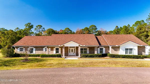 an aerial view of a house with a garden and lake view