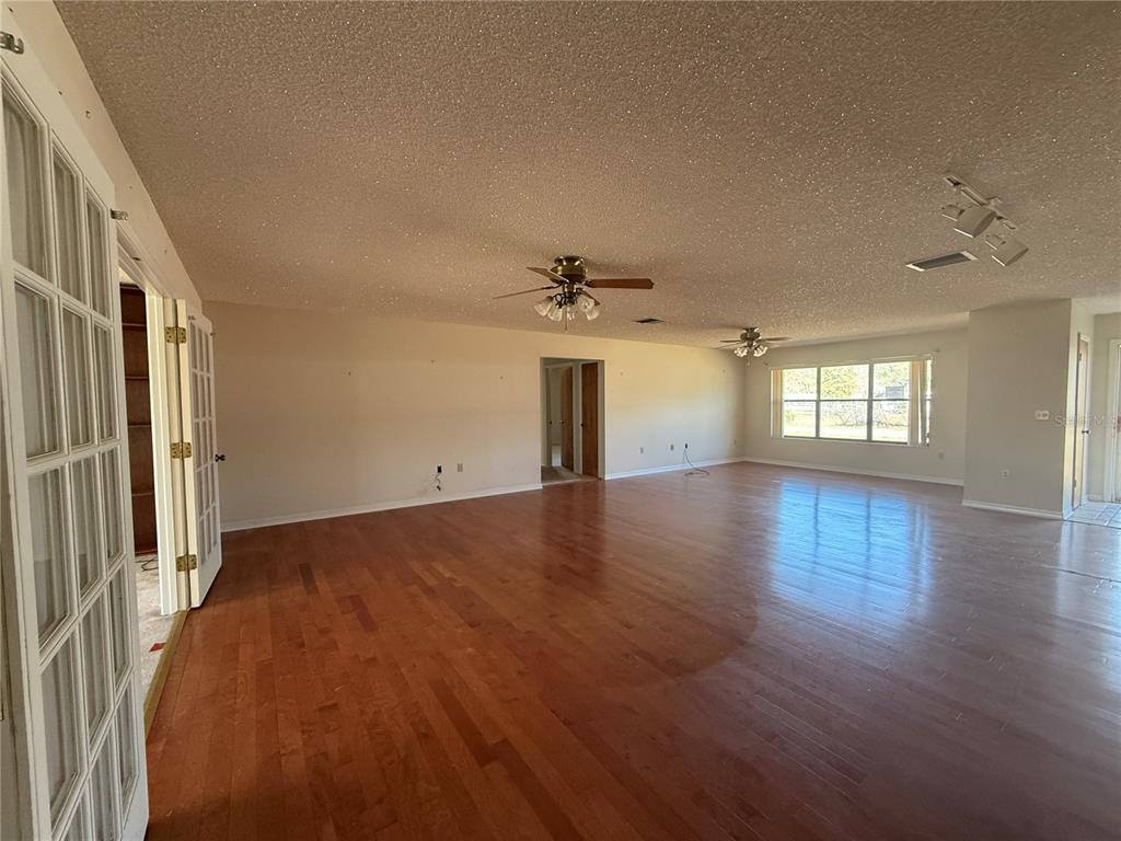 34847 Learn Road Leesburg, FL 34788 - Photo 4 of 25 an empty room with wooden floor and windows