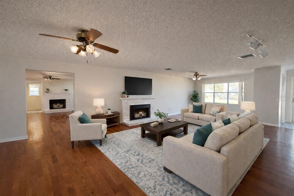 34847 Learn Road Leesburg, FL 34788 - Photo 5 of 25 a living room with furniture a fireplace and a flat screen tv