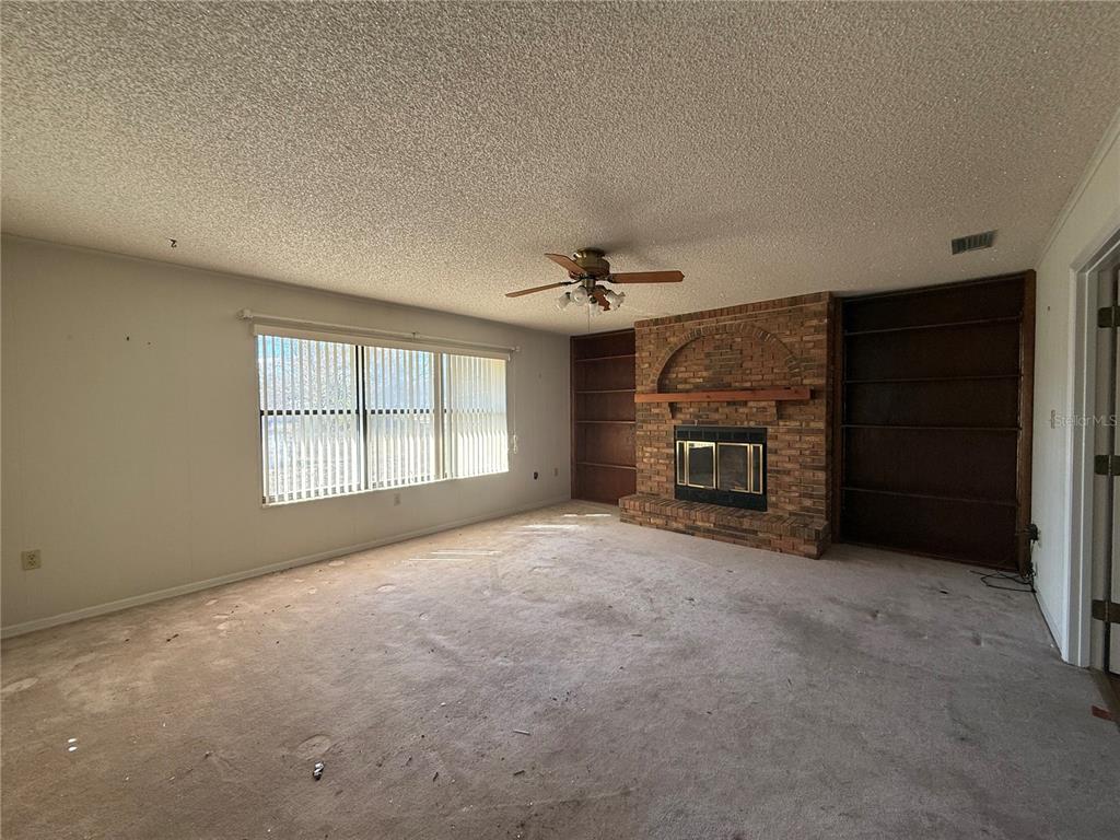 34847 Learn Road Leesburg, FL 34788 - Photo 9 of 25 an empty room with windows and fireplace