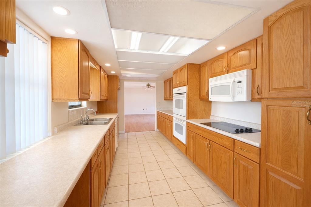 34847 Learn Road Leesburg, FL 34788 - Photo 10 of 25 a large kitchen with stainless steel appliances a large counter top a stove a sink and a refrigerator