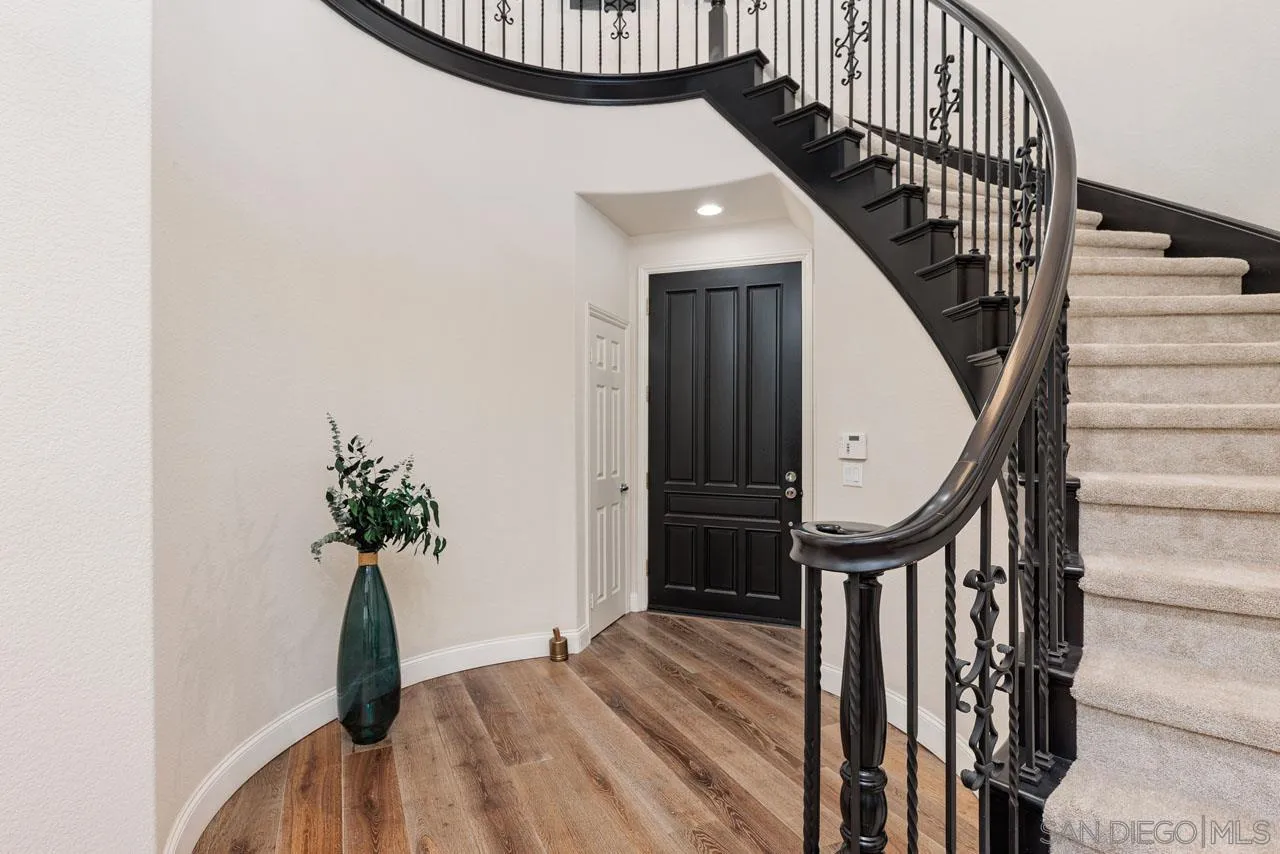 1460 Ravean Court Encinitas, CA 92024 - Photo 14 of 72 a view of staircase with wooden floor and a potted plant