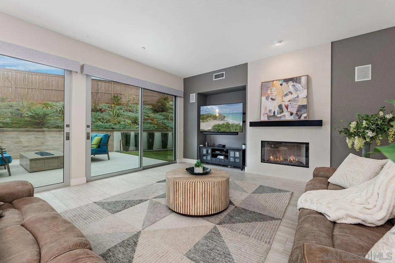 1460 Ravean Court Encinitas, CA 92024 - Photo 21 of 72 a living room with furniture a floor to ceiling window and a fireplace