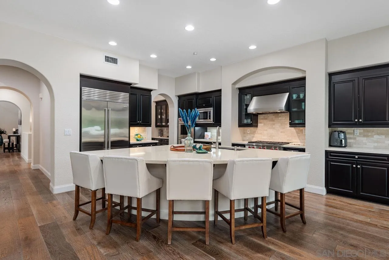 1460 Ravean Court Encinitas, CA 92024 - Photo 24 of 72 a kitchen with a dining table chairs and wooden floor