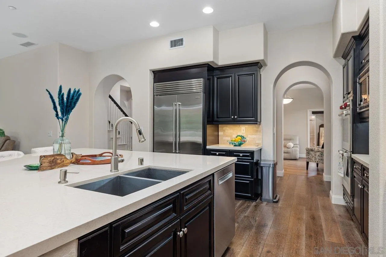1460 Ravean Court Encinitas, CA 92024 - Photo 25 of 72 a kitchen with stainless steel appliances granite countertop a sink a stove and a wooden floors