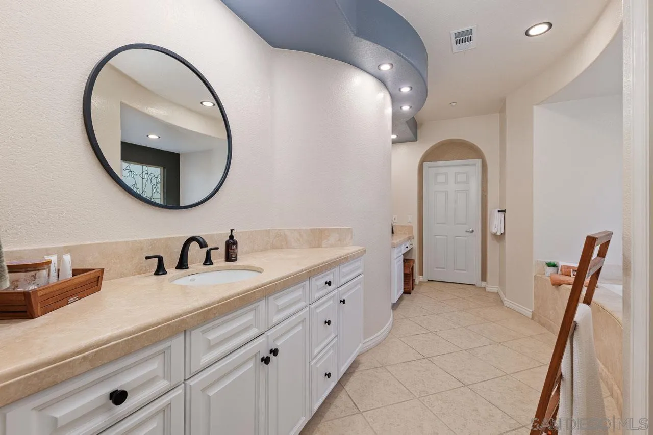 1460 Ravean Court Encinitas, CA 92024 - Photo 42 of 72 a spacious bathroom with a double vanity sink and a mirror