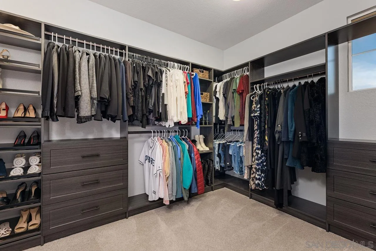 1460 Ravean Court Encinitas, CA 92024 - Photo 45 of 72 a view of walk in closet with clothes and shoes