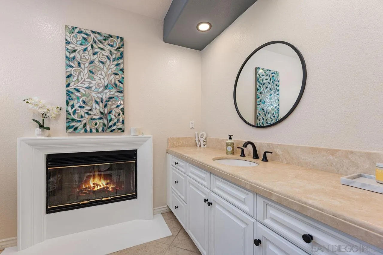 1460 Ravean Court Encinitas, CA 92024 - Photo 46 of 72 a bathroom with a granite countertop sink a mirror and a shower