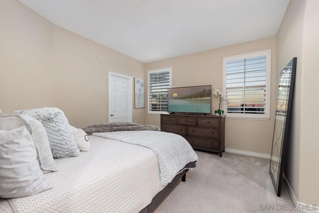 1460 Ravean Court Encinitas, CA 92024 - Photo 48 of 72 a bedroom with a bed and a refrigerator