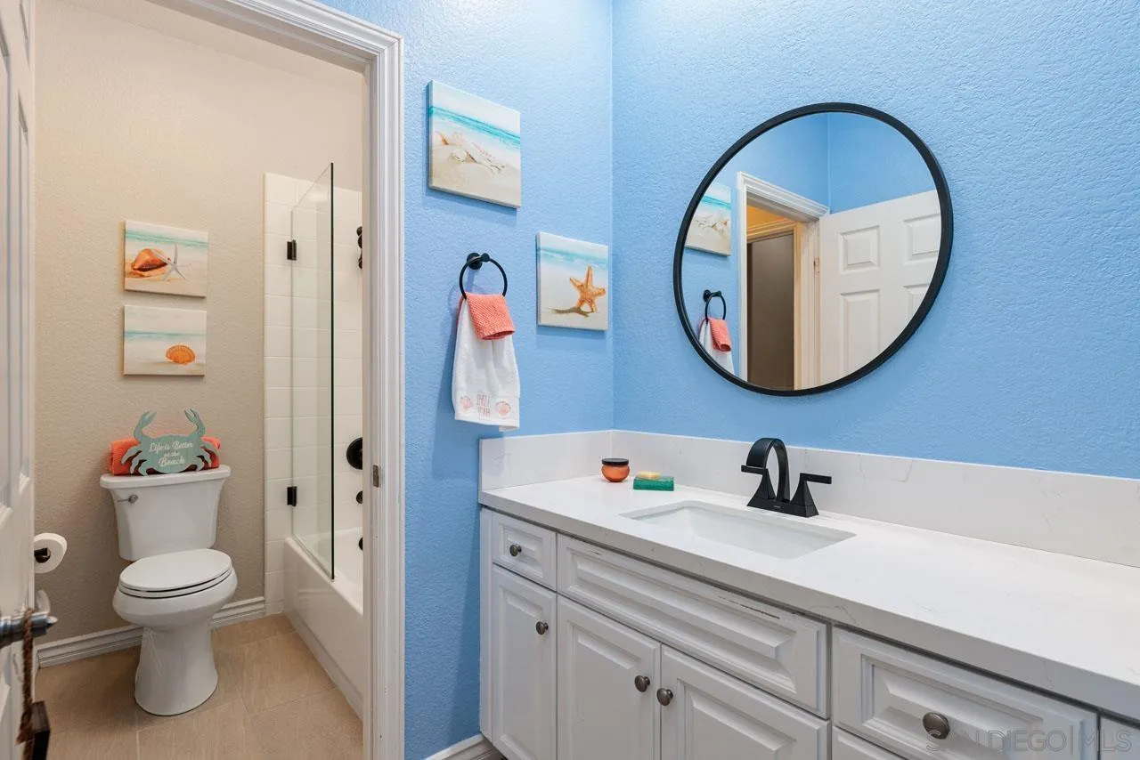 1460 Ravean Court Encinitas, CA 92024 - Photo 50 of 72 a bathroom with a toilet a sink and a mirror