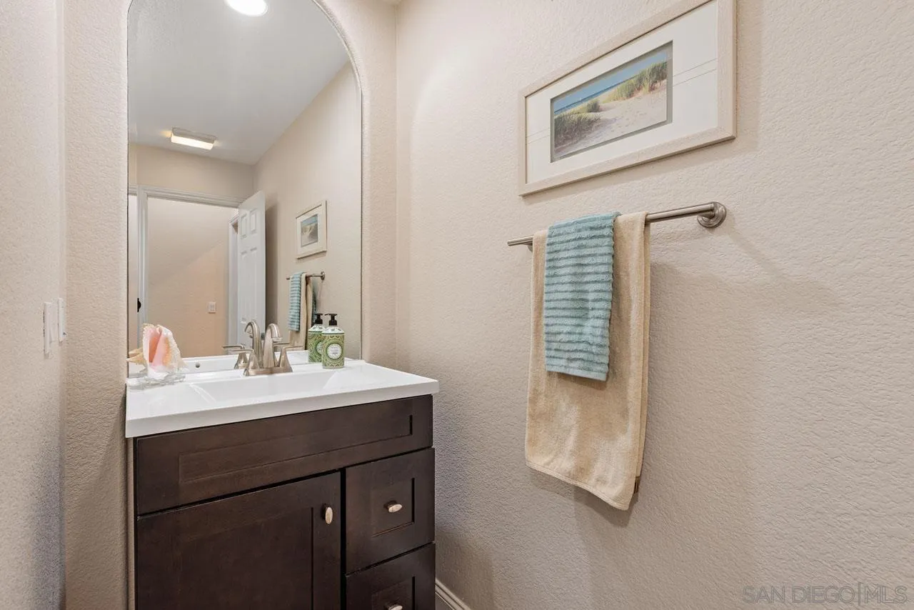 1460 Ravean Court Encinitas, CA 92024 - Photo 55 of 72 a bathroom with a sink a mirror and shower