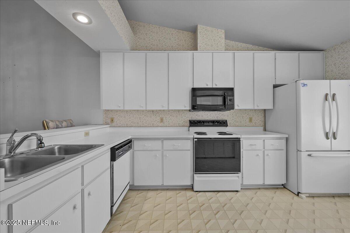 3726 Northwest 53rd Road Gainesville, FL 32653 - Photo 5 of 36 a kitchen with white cabinets and stainless steel appliances