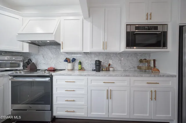 a kitchen with white cabinets and stainless steel appliances