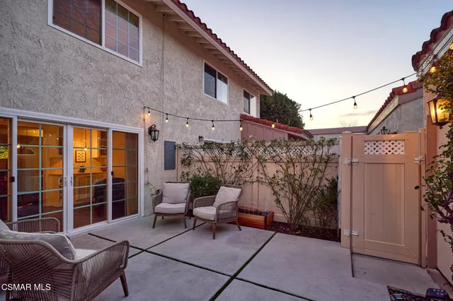 a view of a patio with a table and chairs and floor to ceiling window