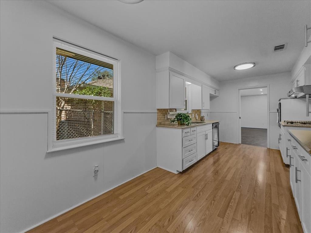 2709 Ripplewood Drive Dallas, TX 75228 - Photo 5 of 24 a kitchen with stainless steel appliances a white cabinets and wooden floors