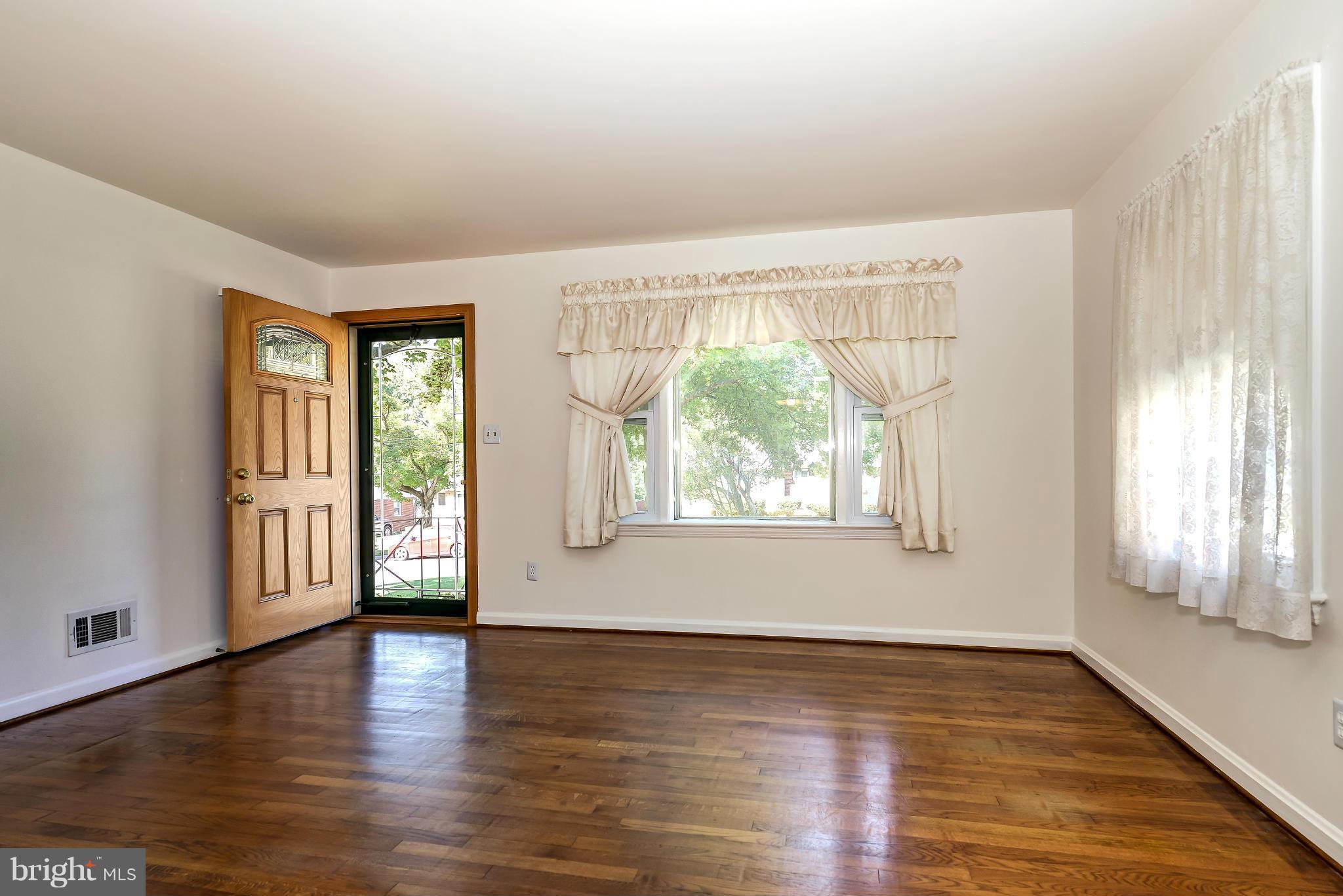 11809 Indigo Road Silver Spring, MD 20906 - Photo 2 of 30 an empty room with wooden floor and windows