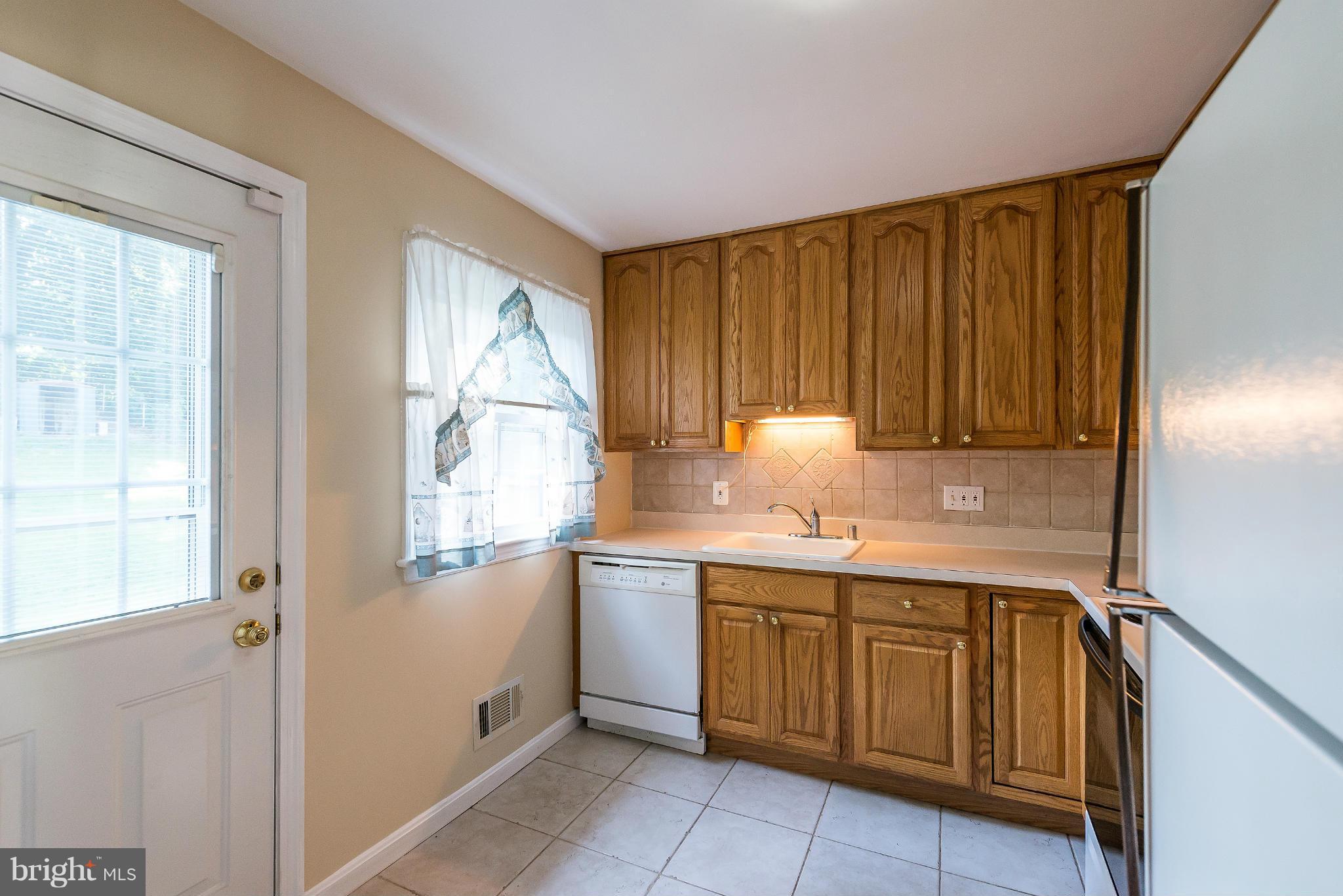 11809 Indigo Road Silver Spring, MD 20906 - Photo 11 of 30 a kitchen with a sink cabinets and wooden floor