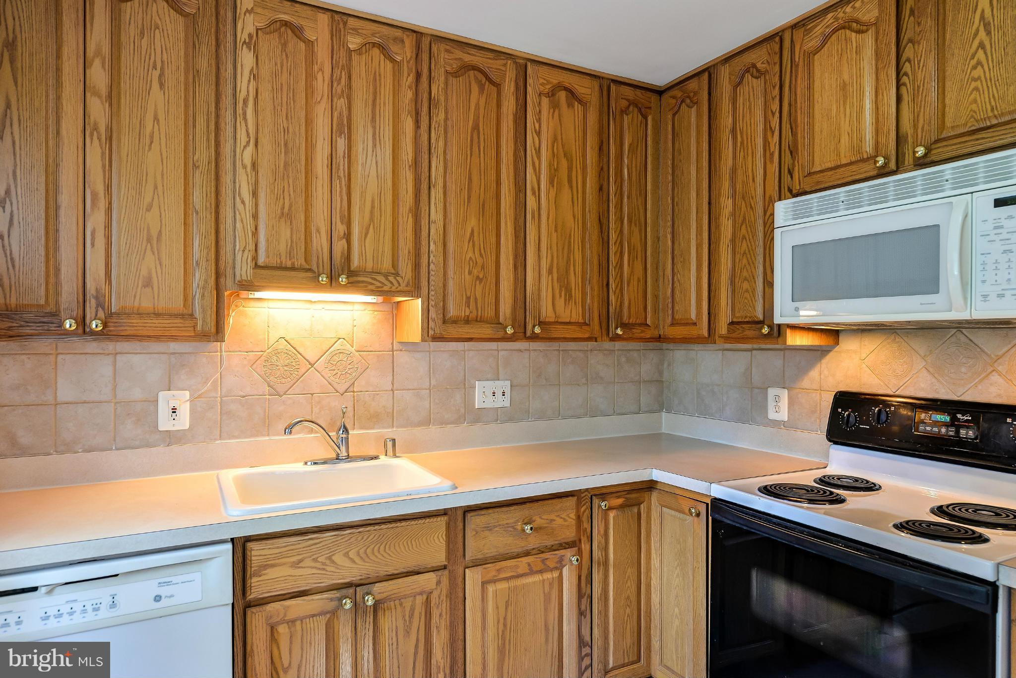11809 Indigo Road Silver Spring, MD 20906 - Photo 12 of 30 a kitchen with stainless steel appliances a stove a sink and a microwave