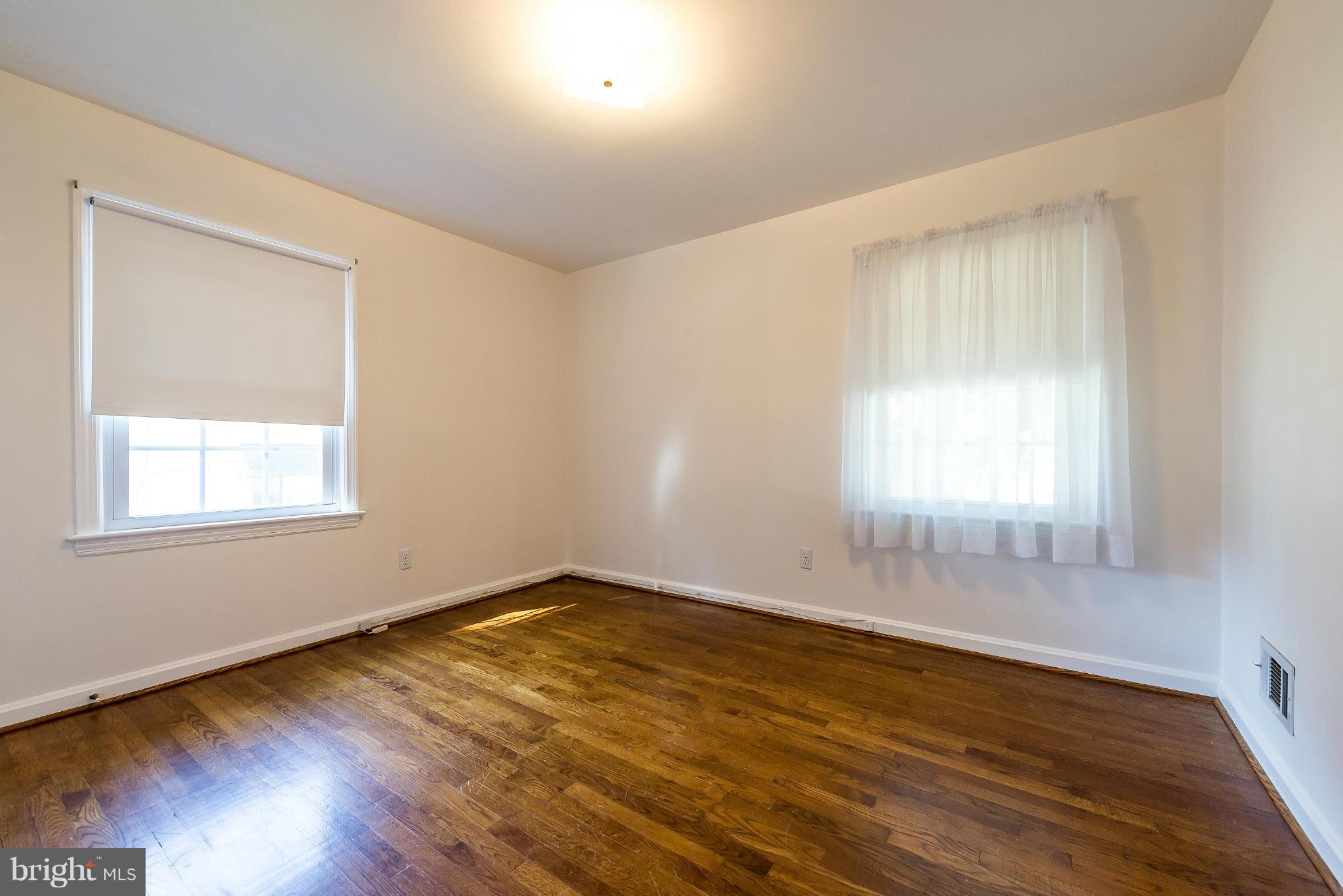 11809 Indigo Road Silver Spring, MD 20906 - Photo 17 of 30 an empty room with wooden floor and windows