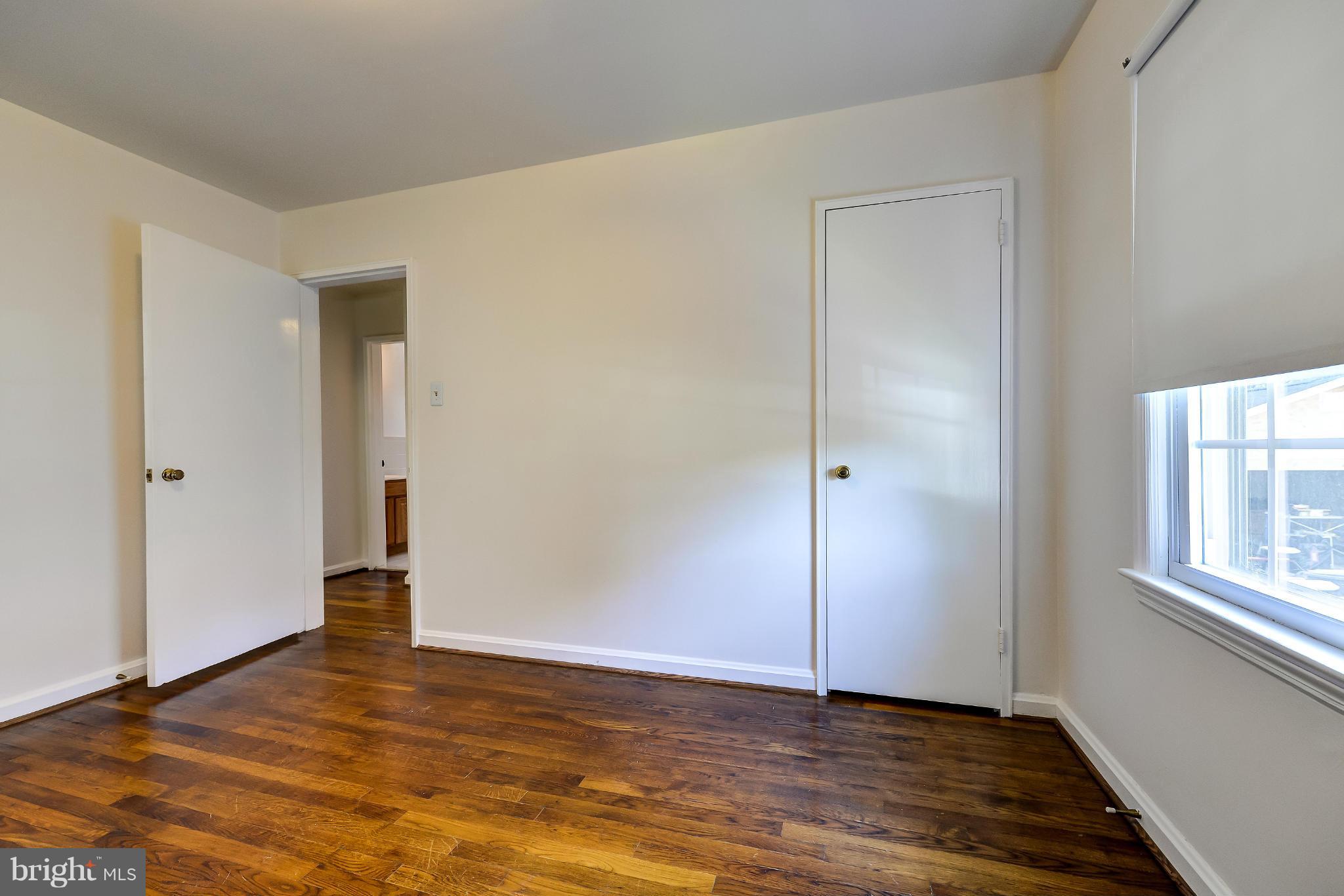 11809 Indigo Road Silver Spring, MD 20906 - Photo 18 of 30 an empty room with wooden floor and windows