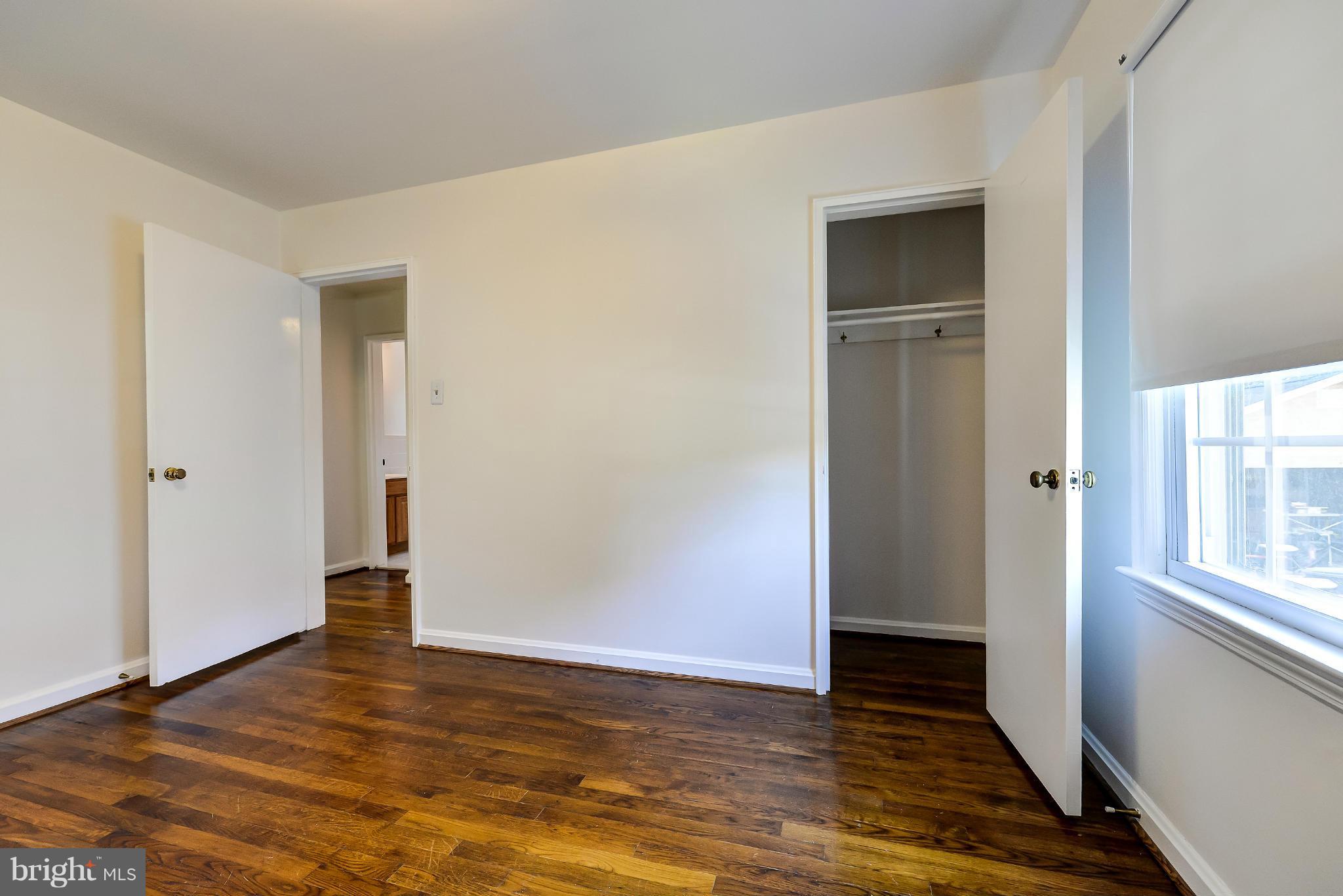 11809 Indigo Road Silver Spring, MD 20906 - Photo 19 of 30 a view of an empty room with wooden floor and a window
