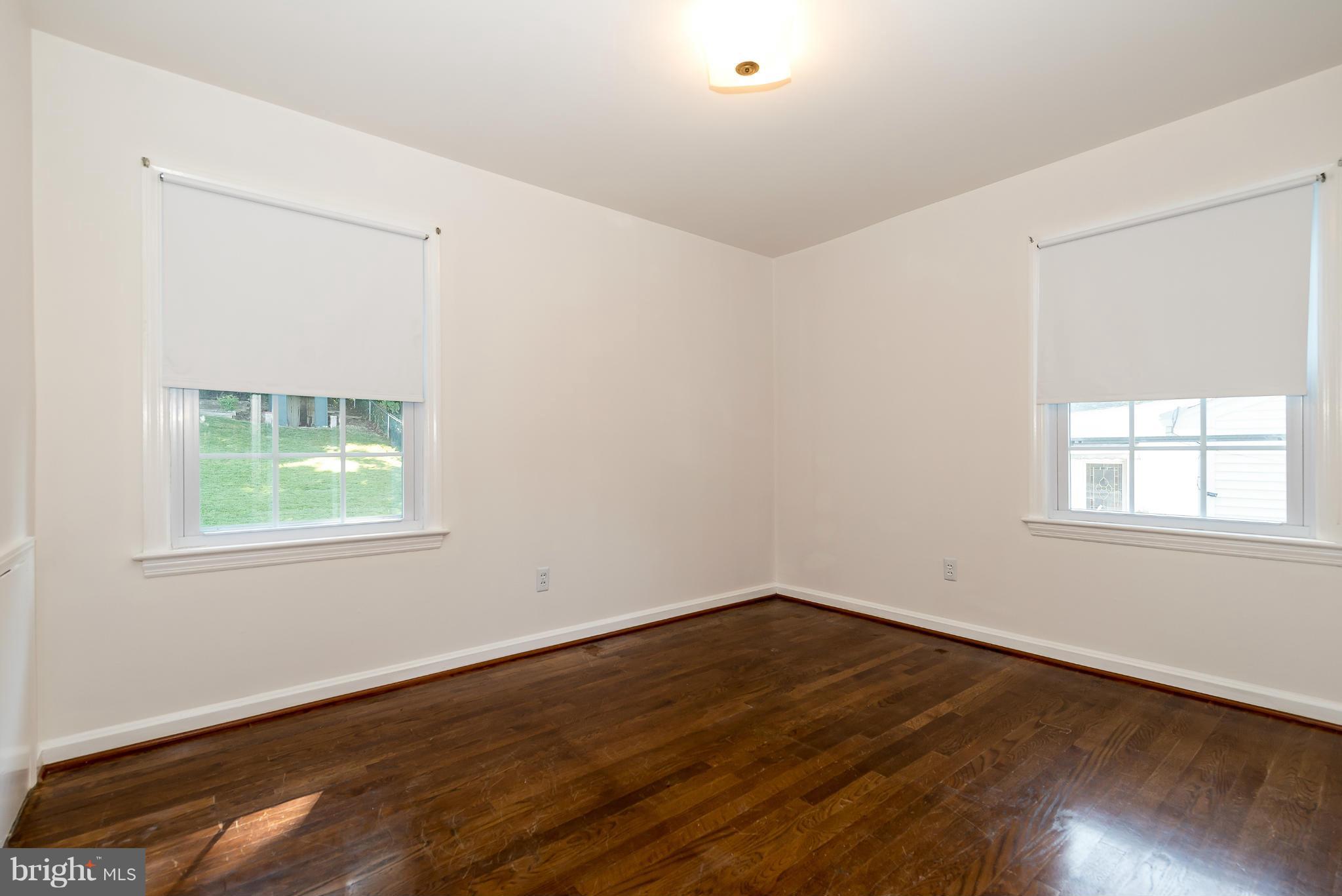 11809 Indigo Road Silver Spring, MD 20906 - Photo 20 of 30 an empty room with wooden floor and windows