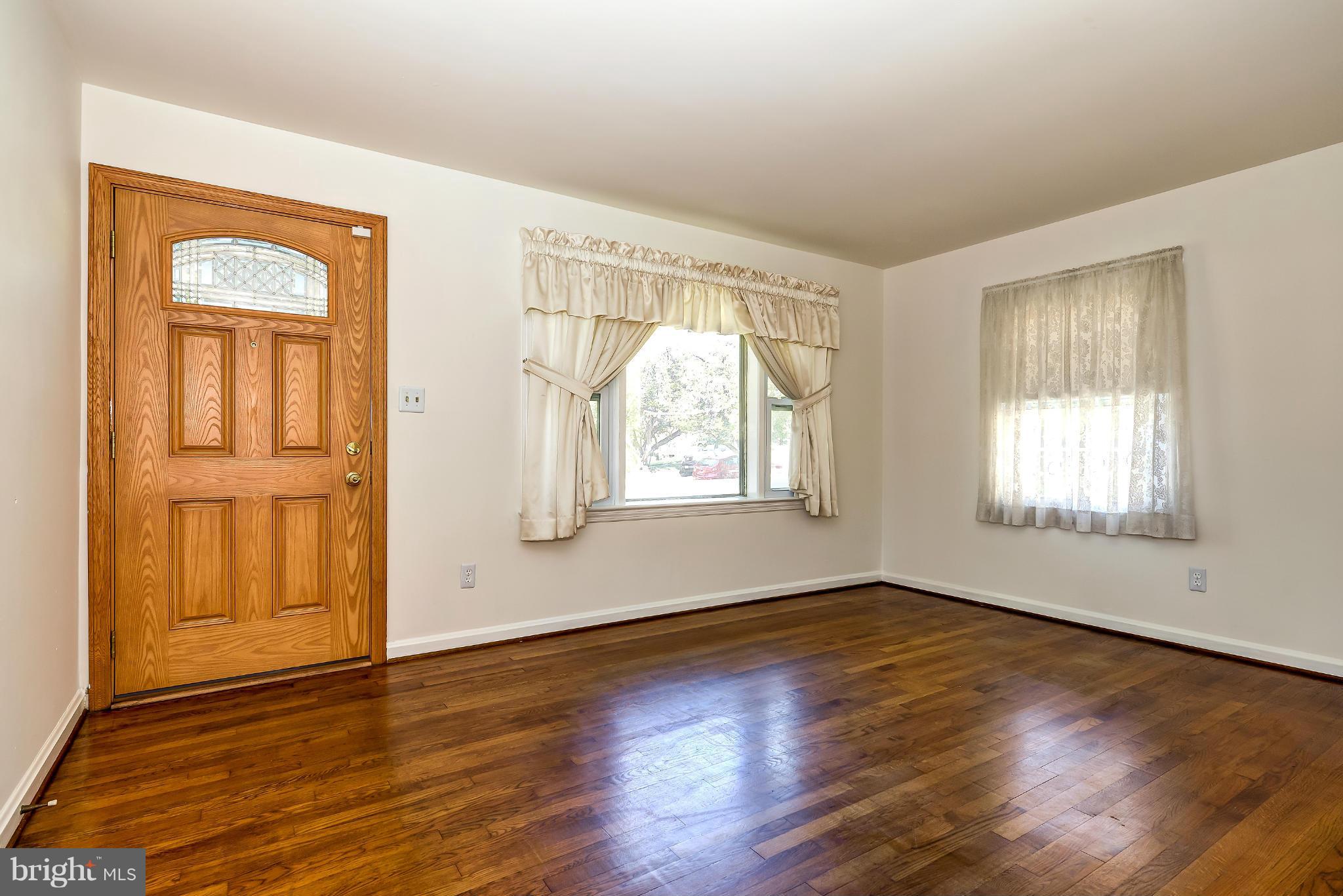 11809 Indigo Road Silver Spring, MD 20906 - Photo 3 of 30 a view of an empty room with wooden floor and a window