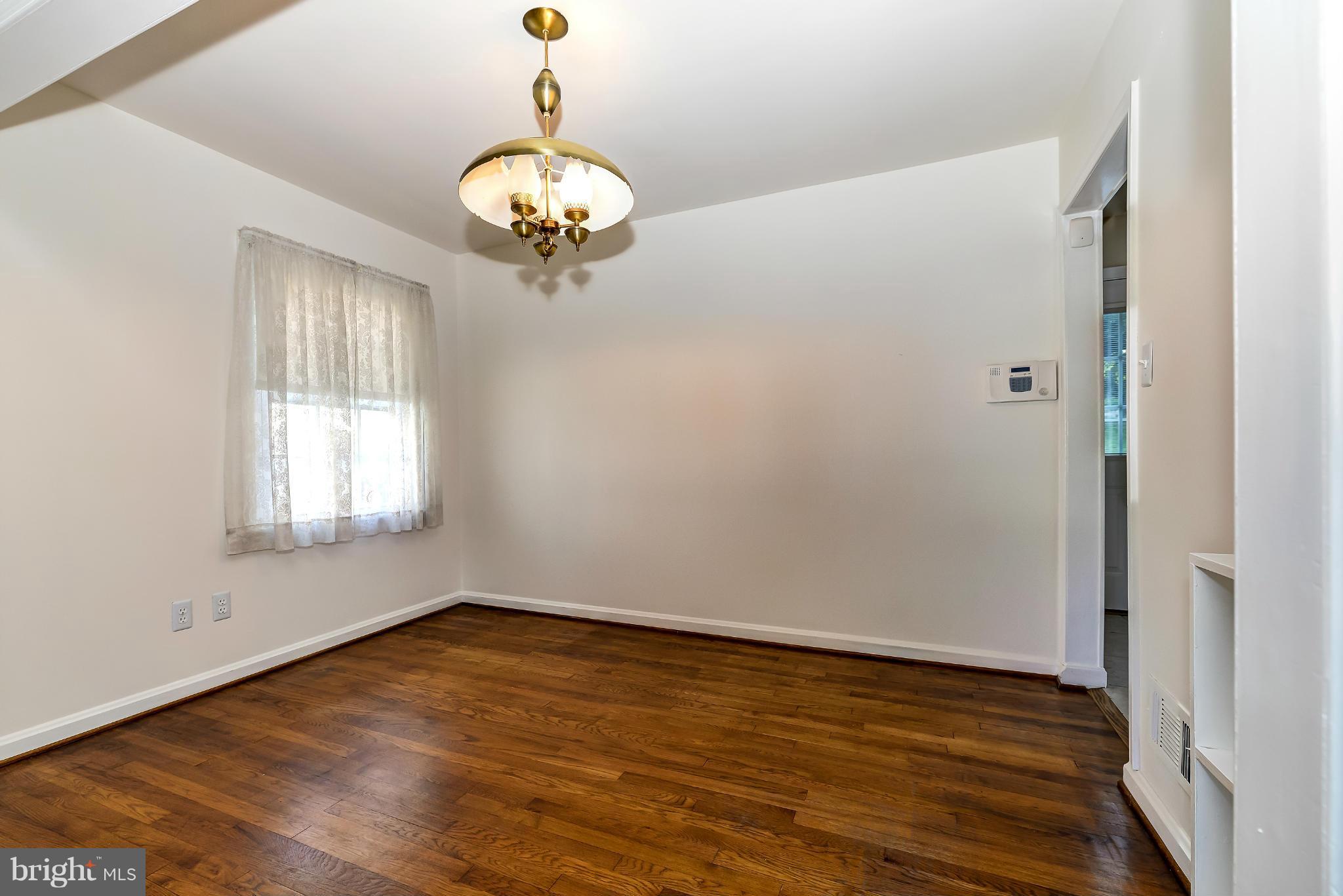 11809 Indigo Road Silver Spring, MD 20906 - Photo 5 of 30 a view of an empty room with wooden floor and a window