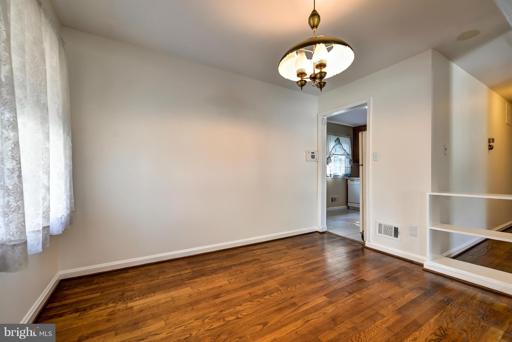 11809 Indigo Road Silver Spring, MD 20906 - Photo 7 of 30 a view of an empty room with wooden floor and a window