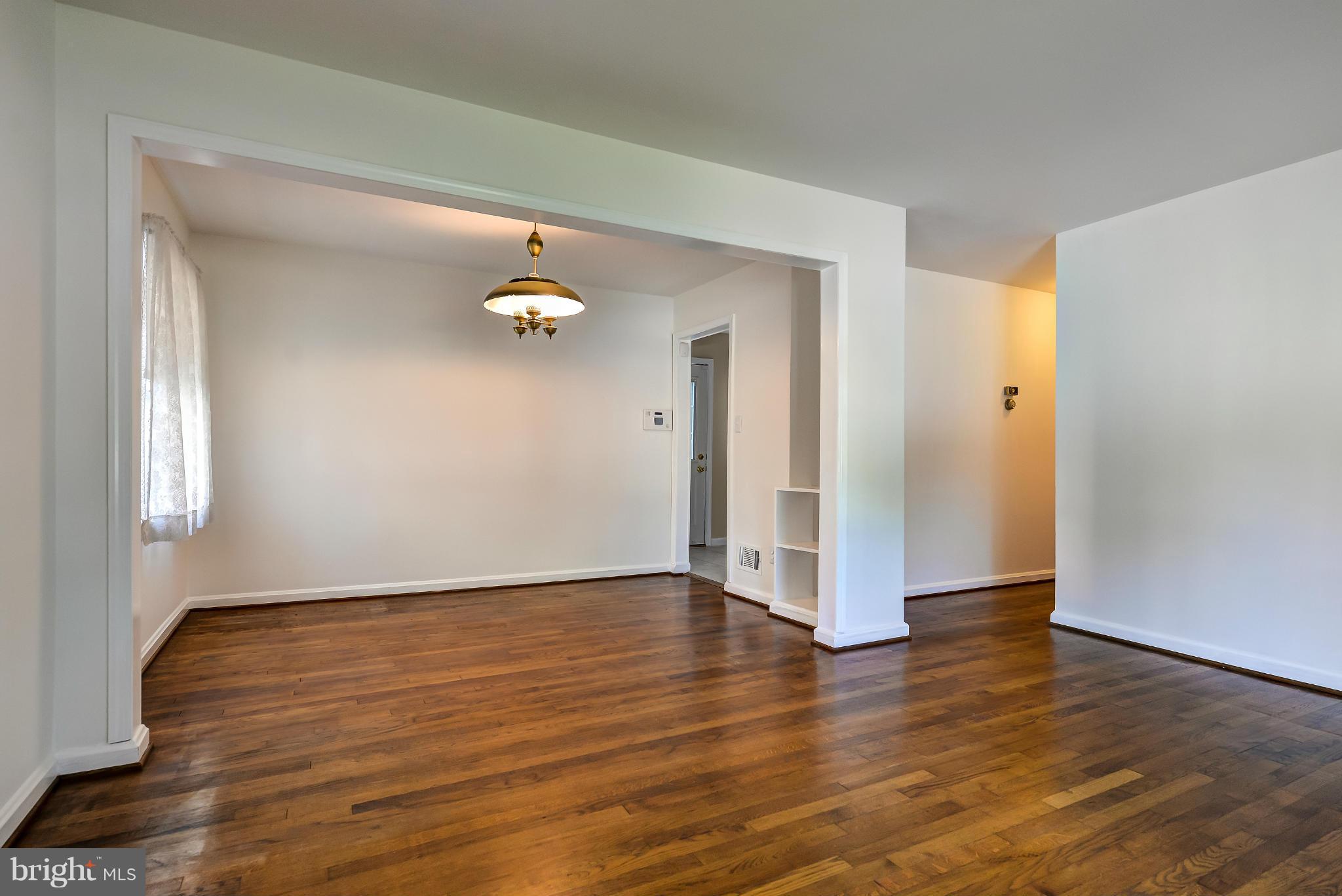 11809 Indigo Road Silver Spring, MD 20906 - Photo 8 of 30 a view of an empty room with wooden floor and a window