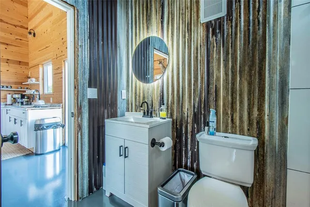 a bathroom with a toilet a sink and a mirror