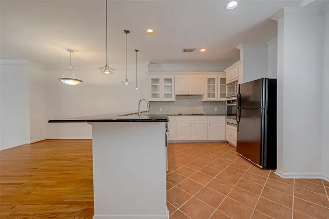 a kitchen with stainless steel appliances granite countertop a refrigerator and a sink