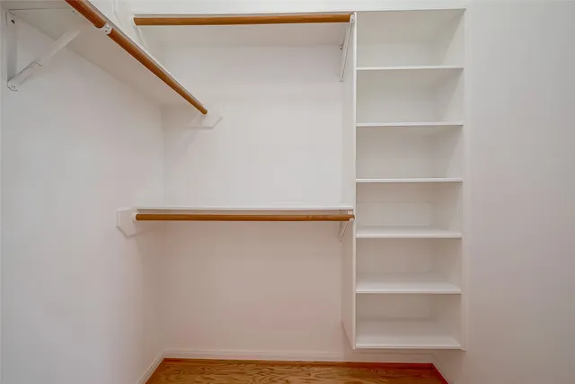 a view of walk in closet with empty racks