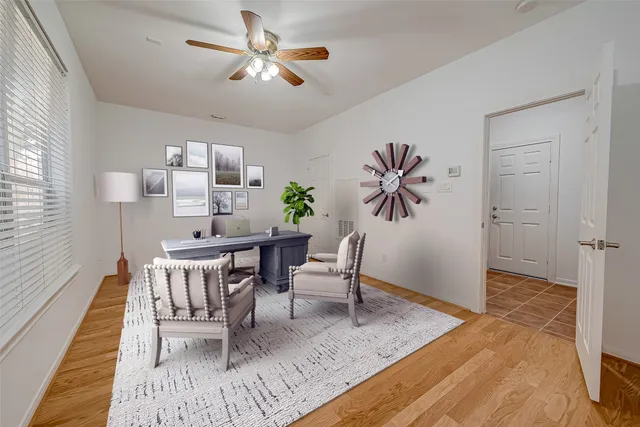 a dining room with furniture a rug a potted plant a chandelier and wooden floor