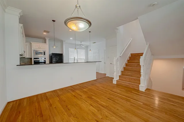 a view of a kitchen with wooden floor and staircase