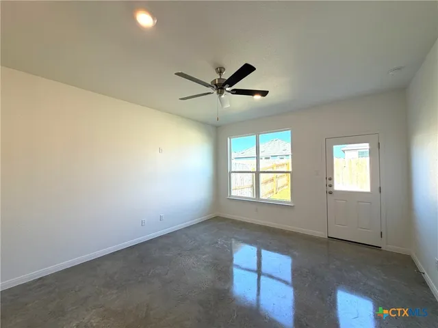a view of a livingroom with a ceiling fan and window