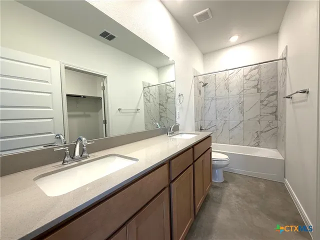 a bathroom with a granite countertop sink a toilet and bathtub