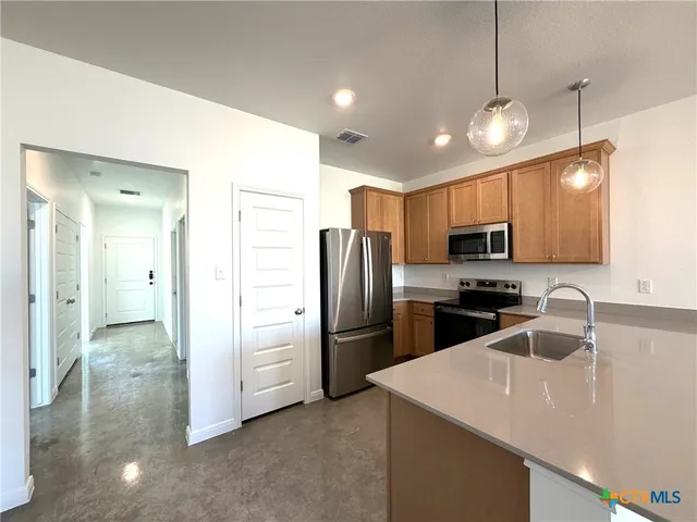 a kitchen with a sink a refrigerator and microwave