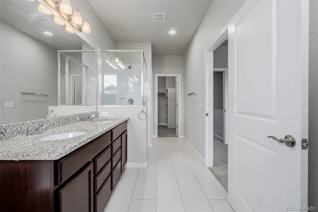 a bathroom with a granite countertop sink a toilet and shower