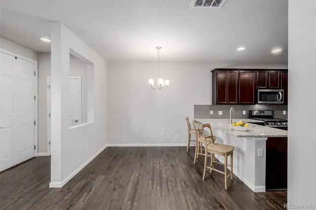 a kitchen with a refrigerator a stove top oven a sink and cabinets