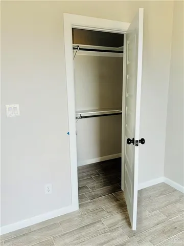 a view of empty room with wooden floor and ceiling fan