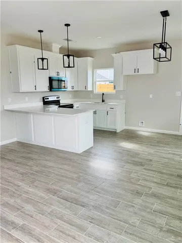 a kitchen with granite countertop white cabinets and stainless steel appliances