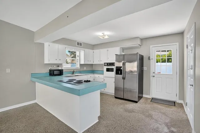 a kitchen with white cabinets sink and stainless steel appliances