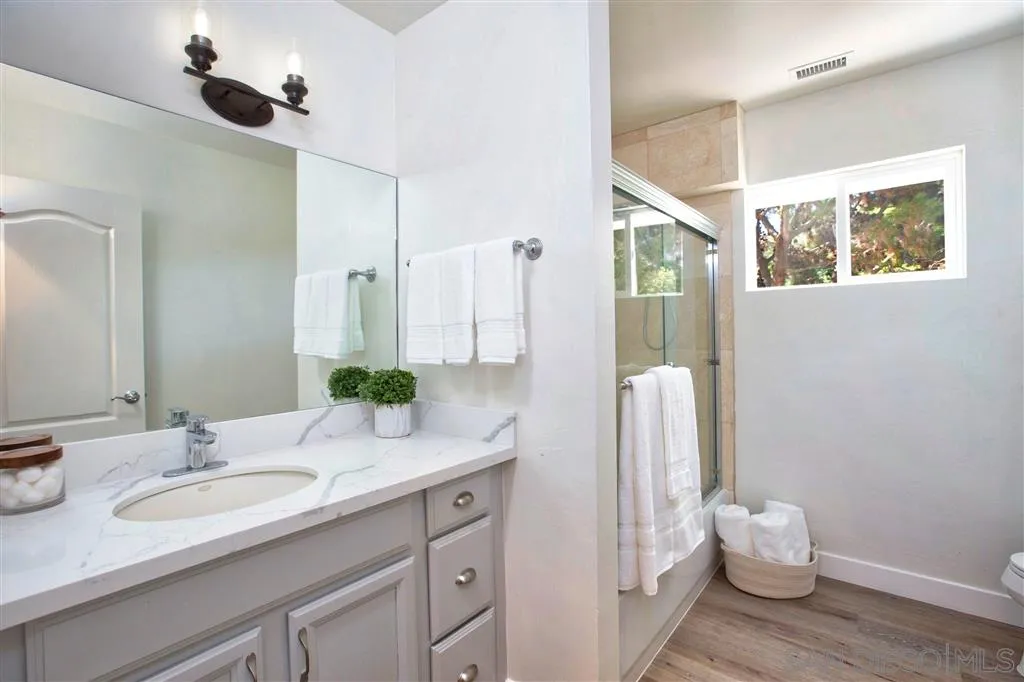 918 Sandpiper Place La Jolla, CA 92037 - Photo 17 of 25 a bathroom with a granite countertop sink and a mirror