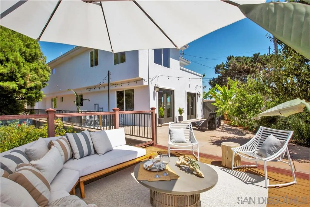 918 Sandpiper Place La Jolla, CA 92037 - Photo 22 of 25 a view of a patio with couches table and chairs under an umbrella