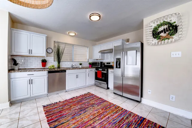 a kitchen with stainless steel appliances granite countertop a refrigerator sink and stove